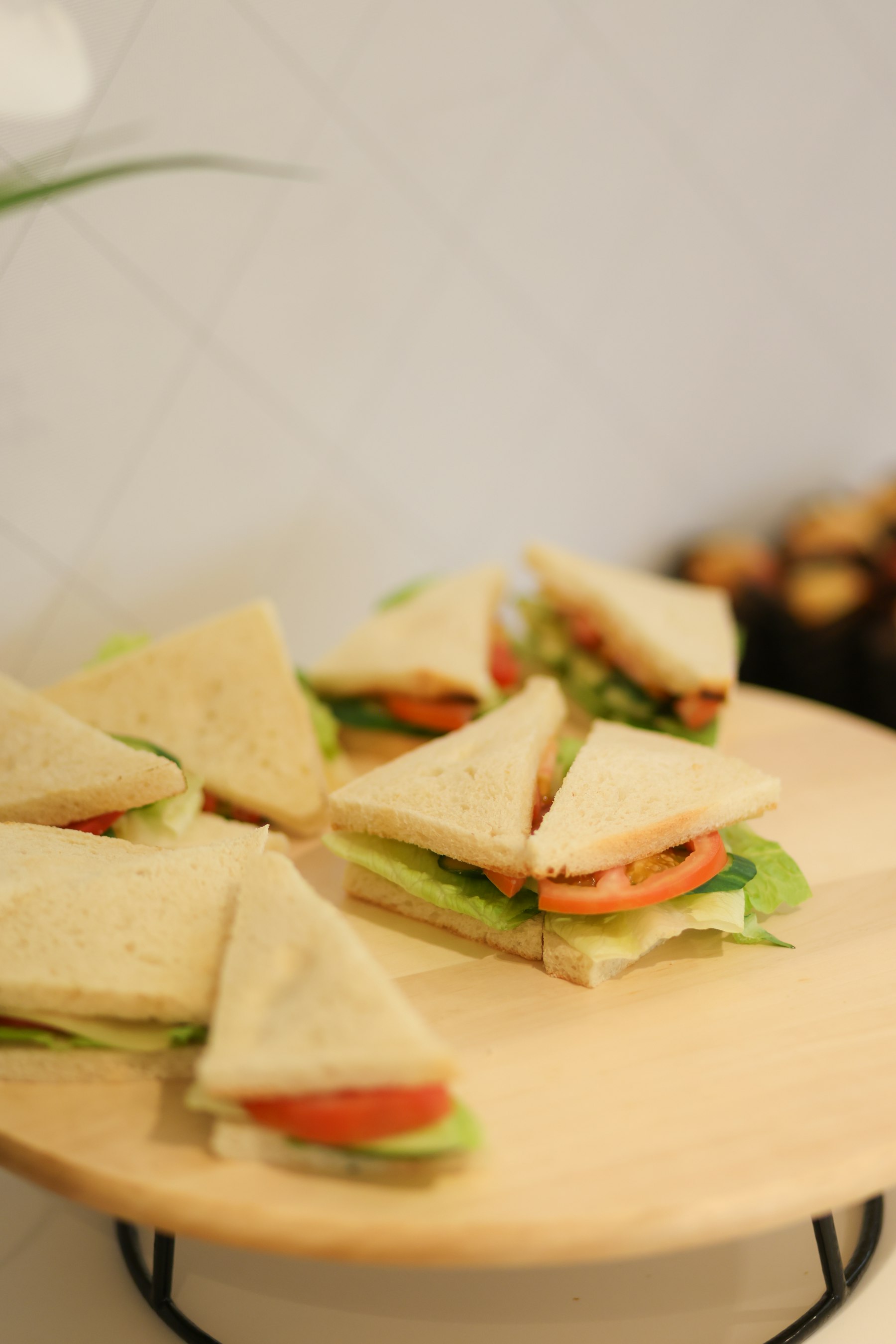 Neat finger sandwiches on a wooden stand