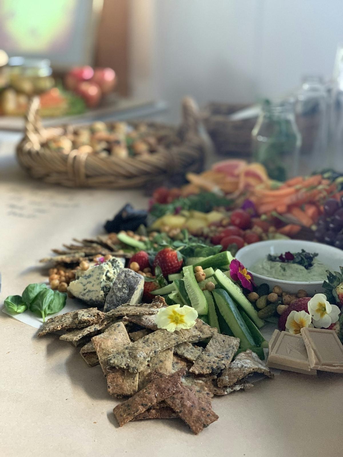 A grazing spread of crackers, cucumber and dips