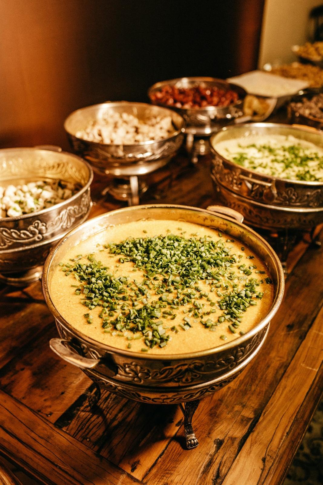 Brass chafing dishes of curry and pulao on a wedding buffet