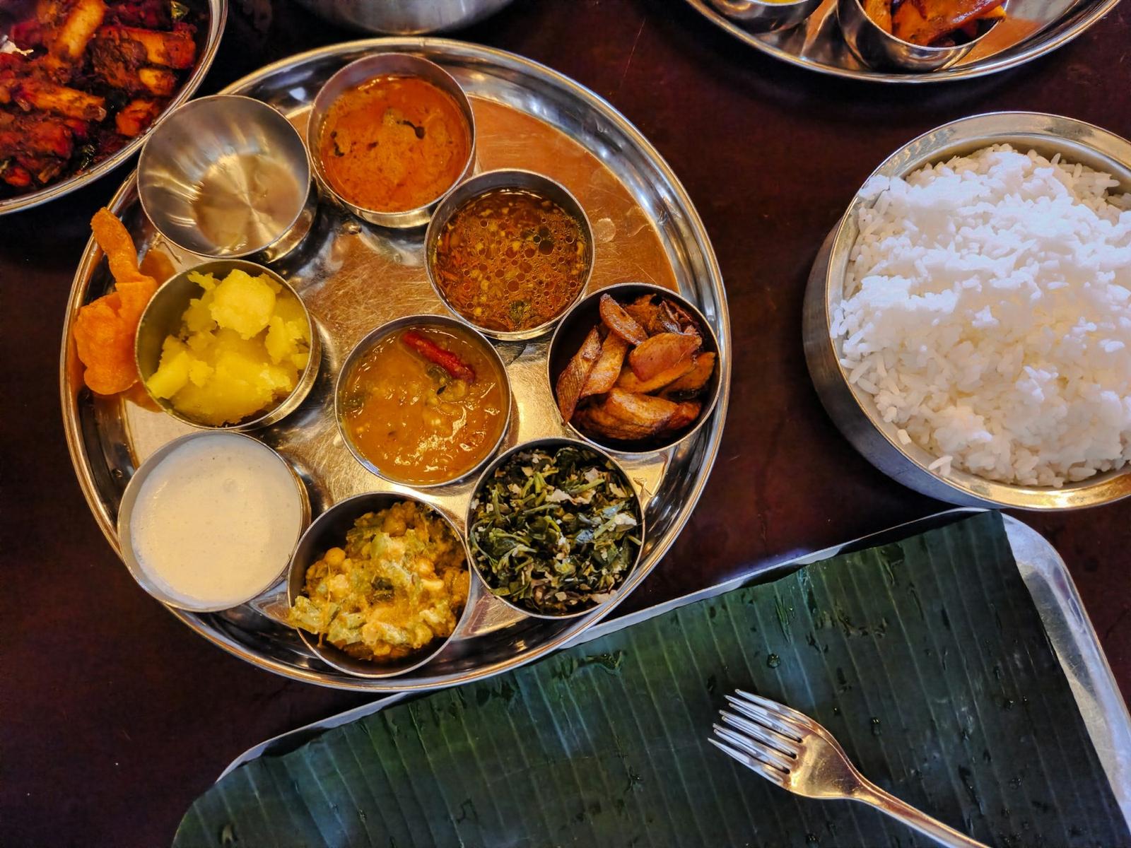 A steel thali with dal, sabzi, rice and roti